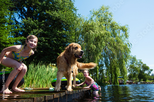 Photo: Happy Children playing with their dog on a lake Happy Children playing with their dog on a lake