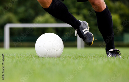 Photo: Detailed view of a footballer / soccer player dribbling the ball Detailed view of a footballer / soccer player dribbling the ball