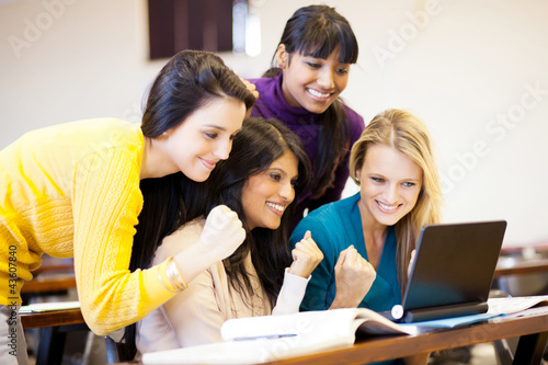 Photo: group of female college students cheering a game on laptop group of female college students cheering a game on laptop