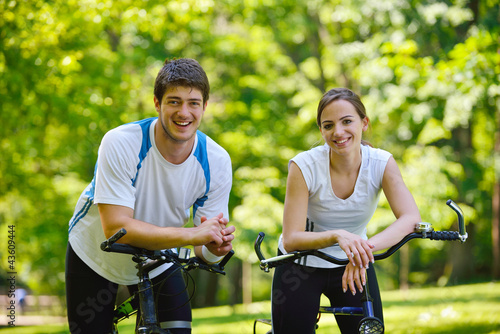 Foto: Happy couple riding bicycle outdoors Happy couple riding bicycle outdoors