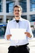 Photo: Businessman holding a blank sign outdoor. Businessman holding a blank sign outdoor.