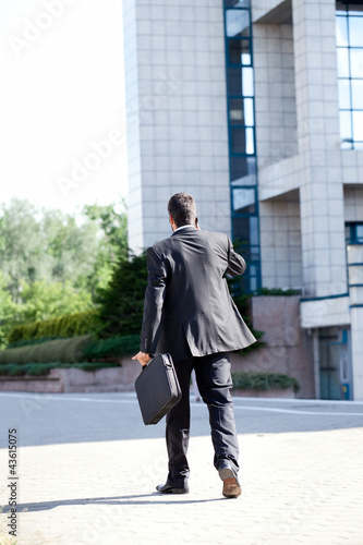 Photo: Business man leaving after a working day Business man leaving after a working day