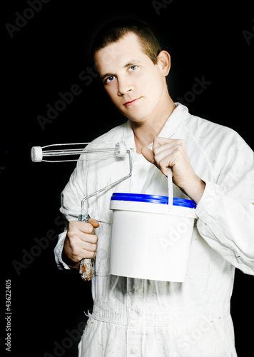 Photo: Painter with roller brush and paint can on black Painter with roller brush and paint can on black