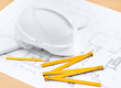 White hard hat near working drawings