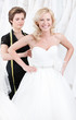 Seamstress tightens up the corset of the wedding gown