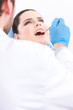 Dentist in blue medical gloves examines the oral cavity
