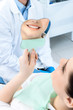 The patient admires her smile looking at the mirror