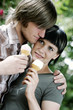 A couple standing near to each other holding an ice-cream cone each