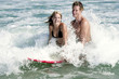 A couple surfing together on the sea