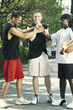 Three basketball players grasping their hands in the middle