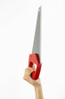 A hand holding up a saw