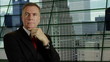 businessman thinking in front of his high rise office
