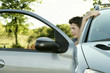 Photo: A guy looking out from an opened car door A guy looking out from an opened car door