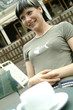 A woman sitting at a cafe with a cup of coffee in front of her