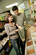 A lady scooping out some snacks while her boyfriend watching