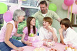 A girl receiving presents from her parents and siblings