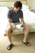 A man sitting on the bed reading documents