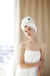 Foto: A woman with her hair and body wrapped up in towel looking at the camera A woman with her hair and body wrapped up in towel looking at the camera