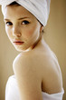Foto: Side shot of a woman with her hair and body wrapped up in towel looking at the camera Side shot of a woman with her hair and body wrapped up in towel looking at the camera