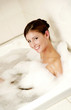 A lady having a bubble bath in the bathtub