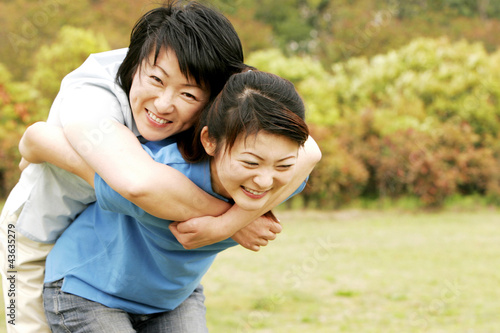 Photo: Adult daughter carrying mother on her back Adult daughter carrying mother on her back