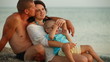 Family Relaxing on a Summer Beach at Sunset