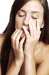 Woman touching her face with her eyes closed