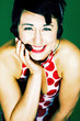 Woman in red and white polka dots dress talking on the headphone 