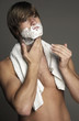 Man applying shaving cream on his face 
