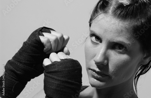 Photo: Black and white picture of a muscular woman practising boxing Black and white picture of a muscular woman practising boxing