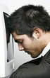 Photo: Man knocking his head against the computer screen Man knocking his head against the computer screen