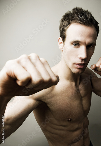 Photo: Shirtless man striking a kung fu pose for the camera Shirtless man striking a kung fu pose for the camera