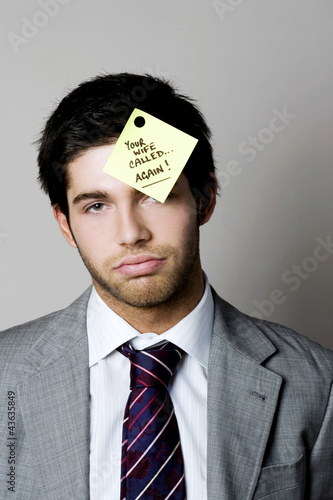 Photo: Businessman with a phone message sticking on his forehead Businessman with a phone message sticking on his forehead