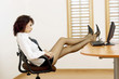 Sexy businesswoman with legs on the table