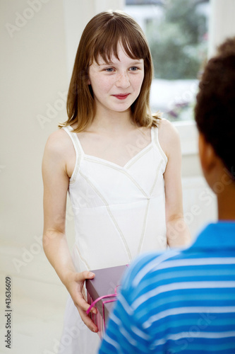 Photo: Girl giving present to her friend Girl giving present to her friend