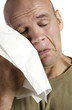 Man wiping his tears with a tissue
