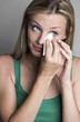 Woman wiping her tears with a tissue