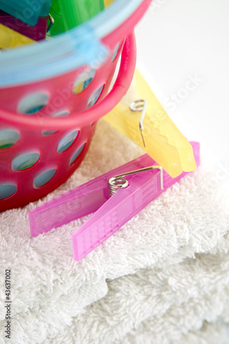 Photo: Colourful plastic clothes pegs and basket Colourful plastic clothes pegs and basket