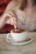 Adding creamer into a cup of cappuccino