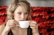 A teenage girl sipping hot tea carefully