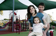 Parents and daughter playing in the playground