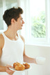 Man with a cup of coffee and a plate of croissants