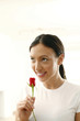 Young woman smelling rose