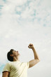 Young man smiling while raising his hand