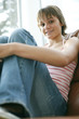 Teenage girl sitting on the couch smiling