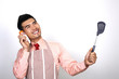 Businessman in apron holding baby bottle and ladle