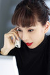 Businesswoman talking on the phone while using laptop