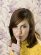 Woman with forefinger at her mouth