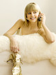 Pretty girl talking on the phone, holding a strappy sandal
