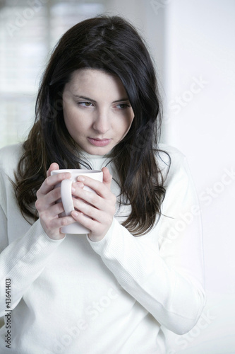 Photo: A woman holding a cup of tea A woman holding a cup of tea